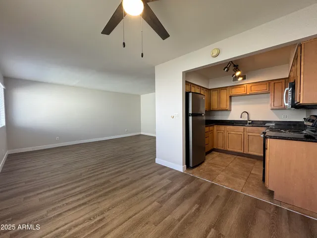 a kitchen with granite countertop a refrigerator and a stove top oven