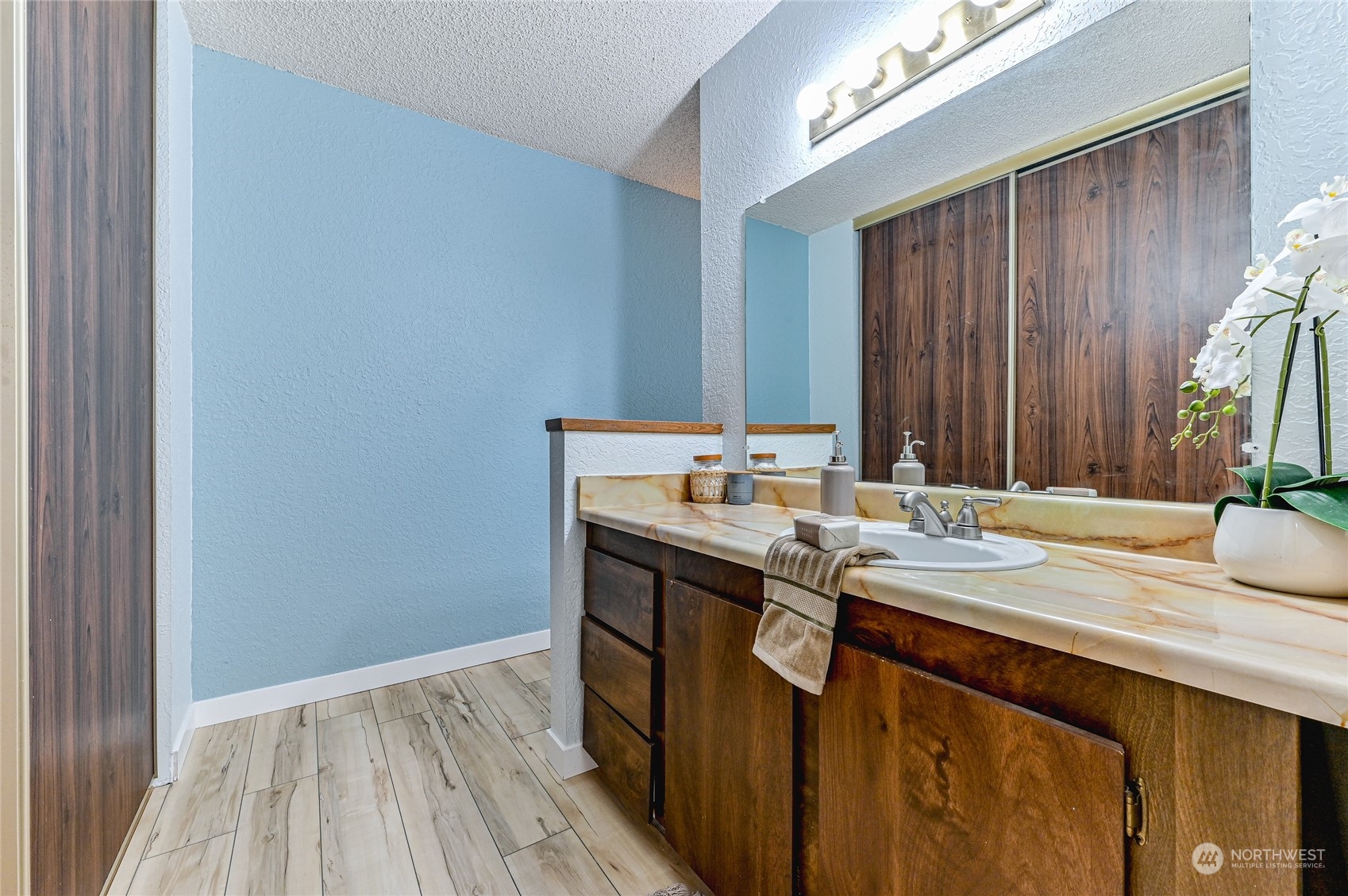 14401 Southeast Petrovitsky Road, Unit E105 Renton, WA 98058 - Photo 21 of 38 a kitchen with a sink and a wooden floor
