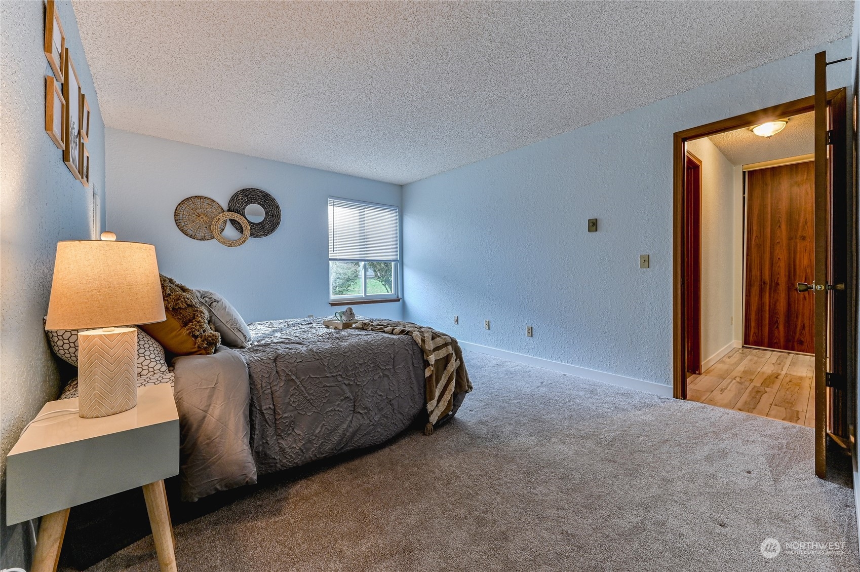 14401 Southeast Petrovitsky Road, Unit E105 Renton, WA 98058 - Photo 22 of 38 a bed room with a bed and a lamp