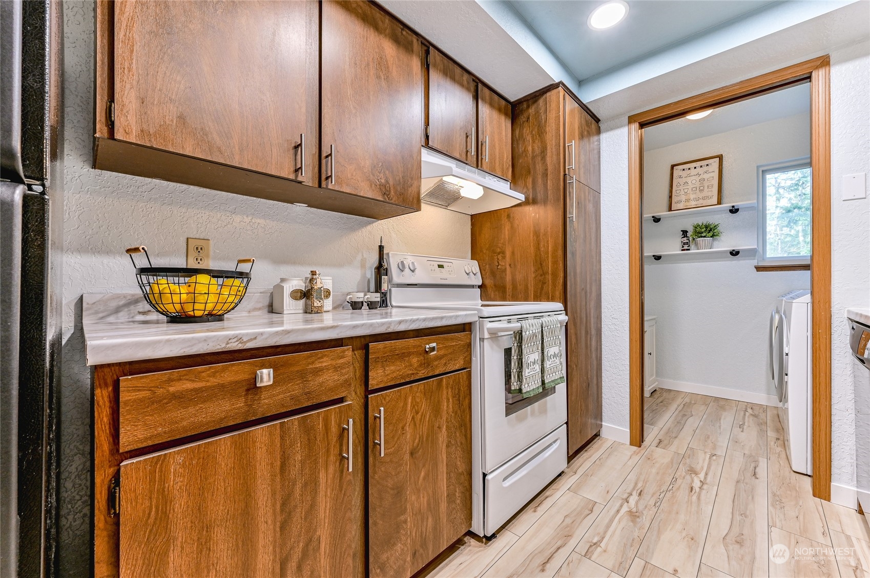 14401 Southeast Petrovitsky Road, Unit E105 Renton, WA 98058 - Photo 4 of 38 a kitchen with a sink a stove cabinets and wooden floor
