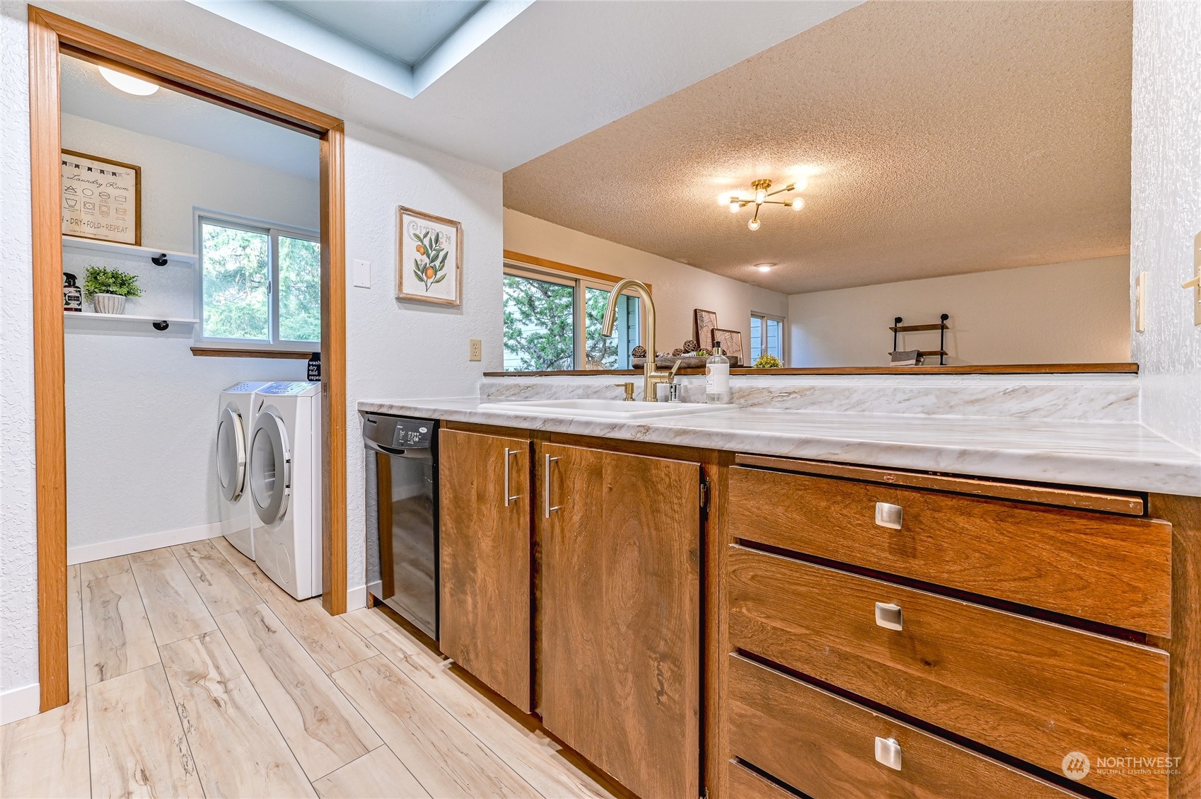 14401 Southeast Petrovitsky Road, Unit E105 Renton, WA 98058 - Photo 5 of 38 a kitchen with stainless steel appliances granite countertop a refrigerator a sink dishwasher and wooden cabinets with wooden floor