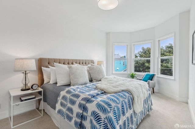 a bed sitting in a bedroom next to a window