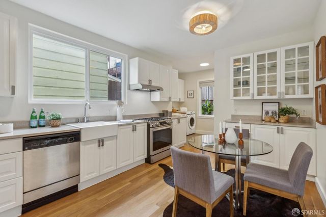a kitchen with a stove a table and chairs in it