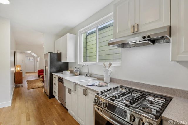 a kitchen with a stove a sink and a refrigerator