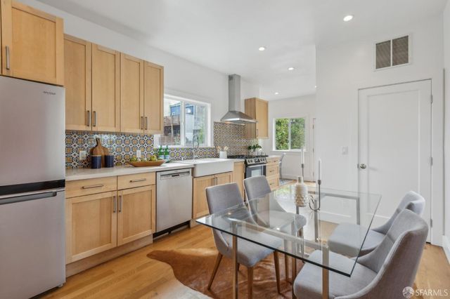a kitchen with a dining table chairs and white cabinets