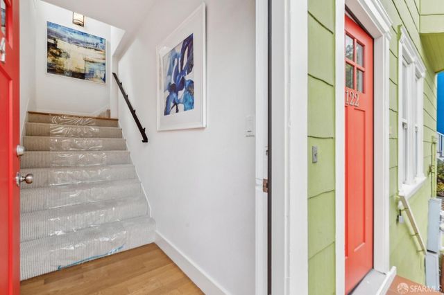 a view of a hallway with wooden floor and entryway