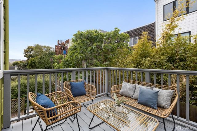 a roof deck with couches and wooden floor
