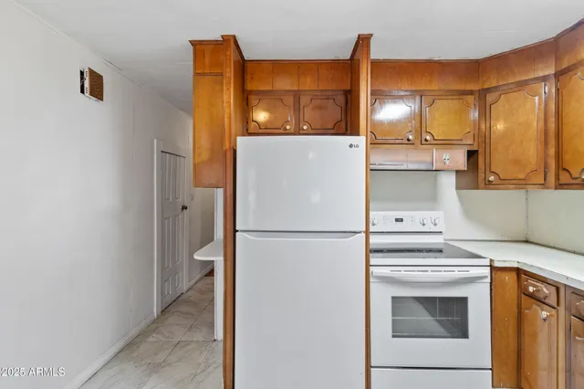 a white refrigerator freezer and a stove sitting inside of a kitchen