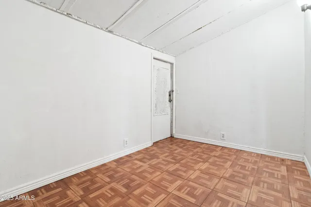 a view of a bedroom with wooden floor and a window