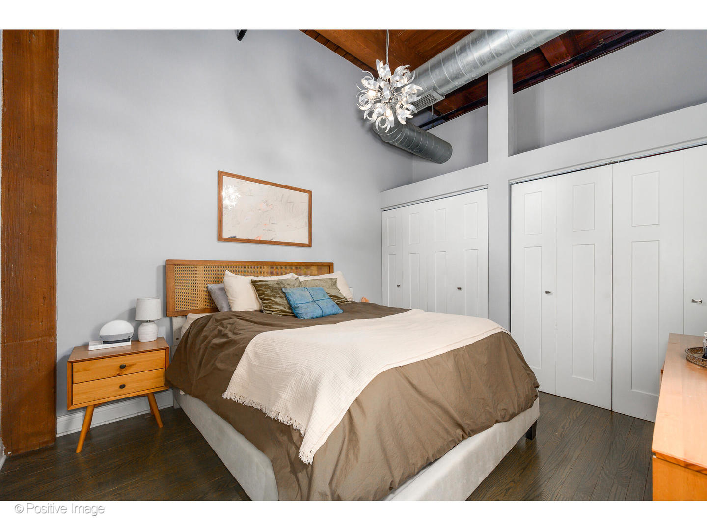 1500 West Monroe Street, Unit 215 Chicago, IL 60607 - Photo 10 of 14 a bedroom with a bed a chandelier and a table