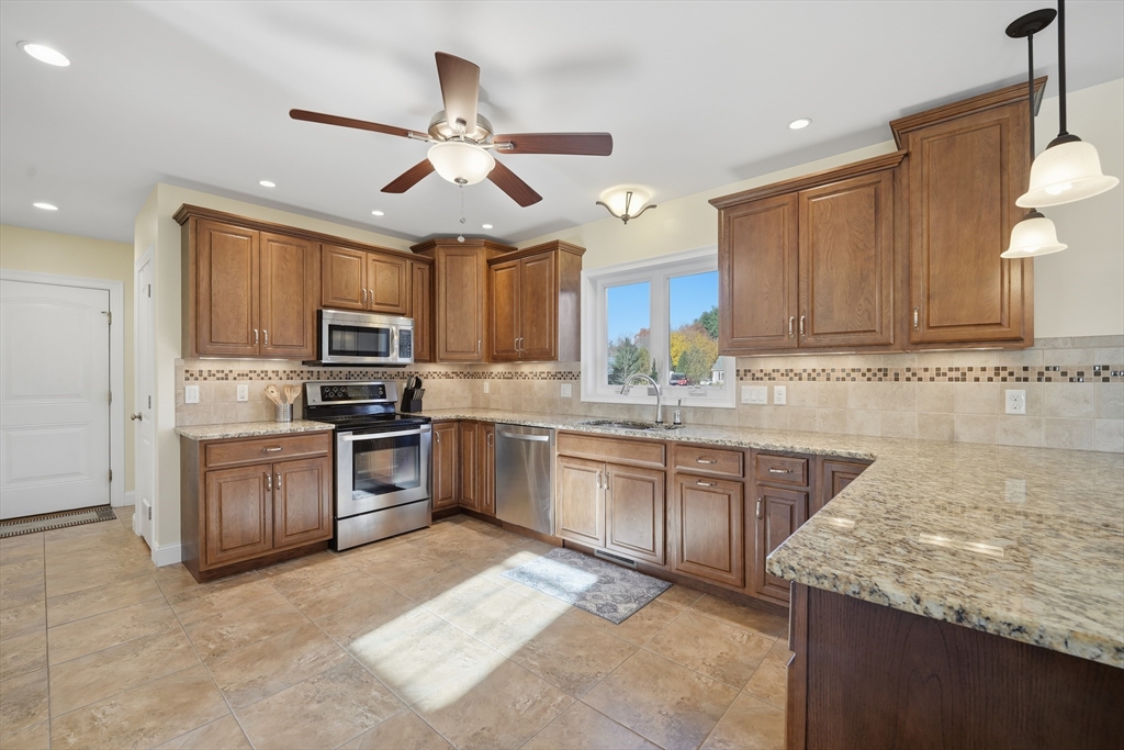 559 East State Street Granby, MA 01033 - Photo 5 of 41 a kitchen with granite countertop stainless steel appliances and wooden cabinets