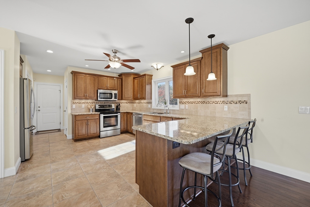 559 East State Street Granby, MA 01033 - Photo 6 of 41 a kitchen with stainless steel appliances kitchen island granite countertop a kitchen island and chairs in it