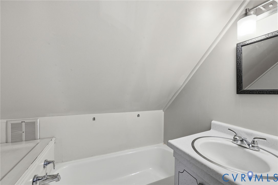 3355 Duke Road Powhatan, VA 23139 - Photo 30 of 67 a bathroom with a bathtub sink vanity and mirror