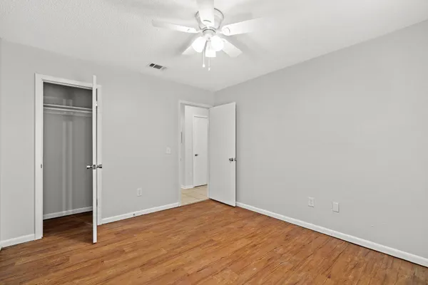 a view of an empty room with wooden floor