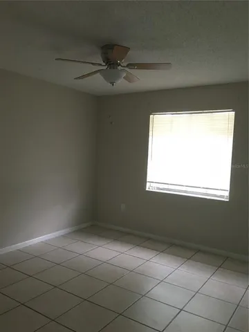 a backyard of a house with large trees and barbeque oven