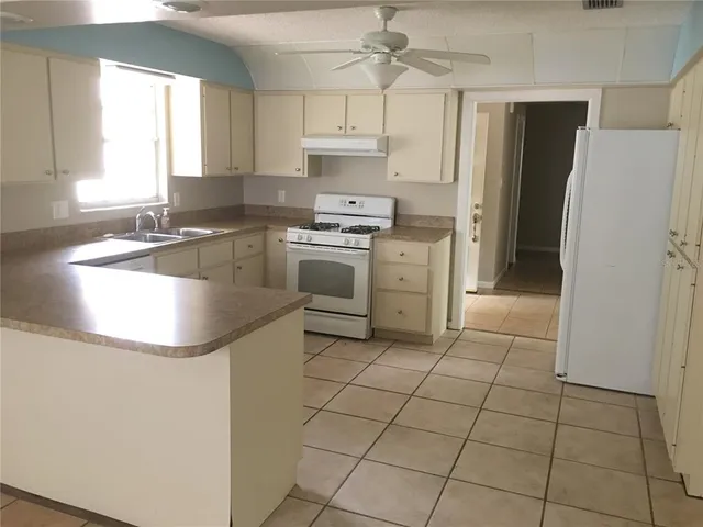 a kitchen with kitchen island a stove a sink and a refrigerator