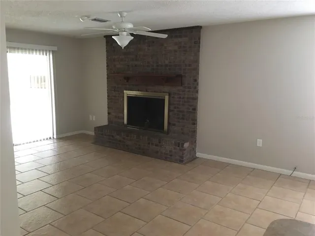 an empty room with windows and fireplace