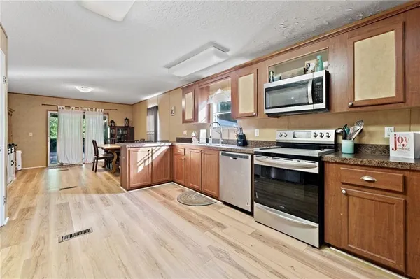 a large kitchen with stainless steel appliances granite countertop a stove and a sink
