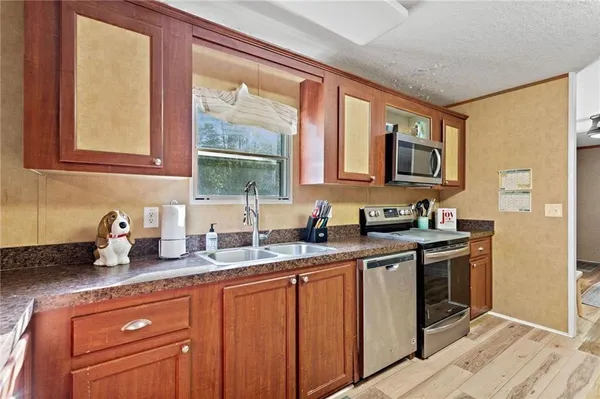 a kitchen with stainless steel appliances granite countertop a sink stove and cabinets