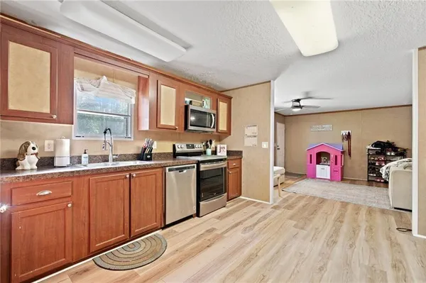 a kitchen with stainless steel appliances granite countertop a stove cabinets and wooden floor