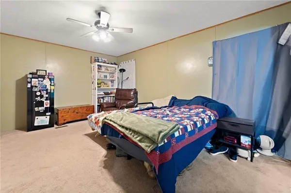 a bedroom with a bed and a bookshelf with wooden floor