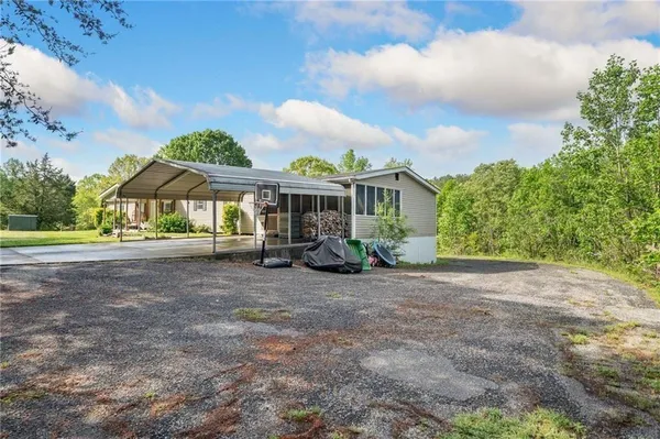 a view of a house with backyard and a tree