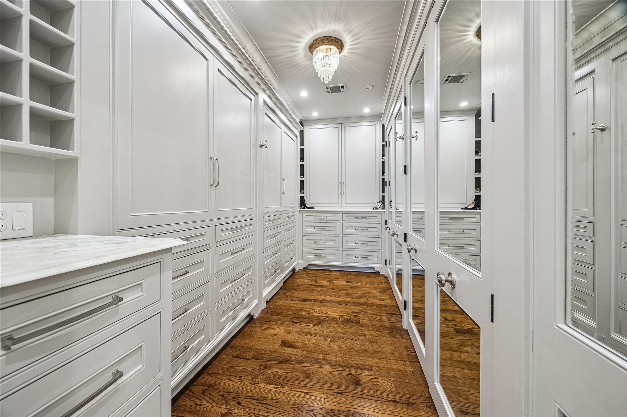 2368 Timber Lane Houston, TX 77027 - Photo 27 of 46 Adorned in custom boutique-style built-ins designed to maximize both beauty and functionality, the primary closet showcases sleek integrated cabinetry concealing an impressive amount of customized storage, creating a polished dressing space that feels both elevated and exceptionally organized.