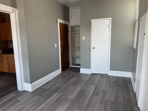 an empty room with wooden floor and entrance