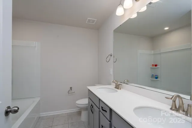 a bathroom with a sink vanity granite and toilet