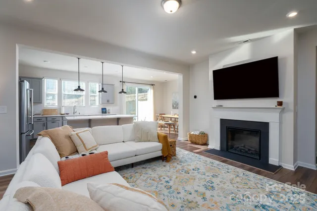 a living room with furniture a fireplace and a flat screen tv