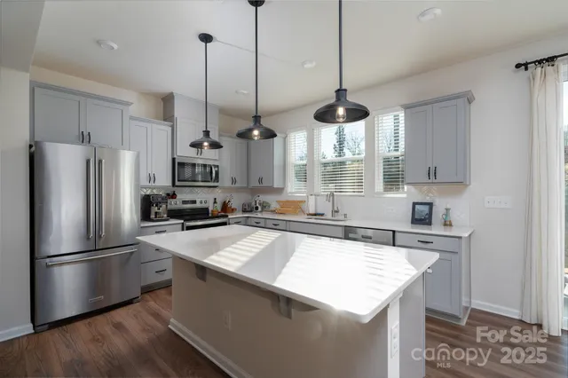 a kitchen with stainless steel appliances granite countertop a sink a refrigerator a stove a microwave and island