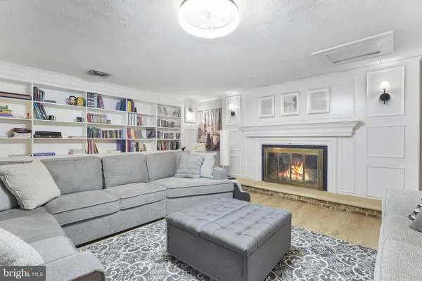 a living room with furniture couches and a dining table with wooden floor