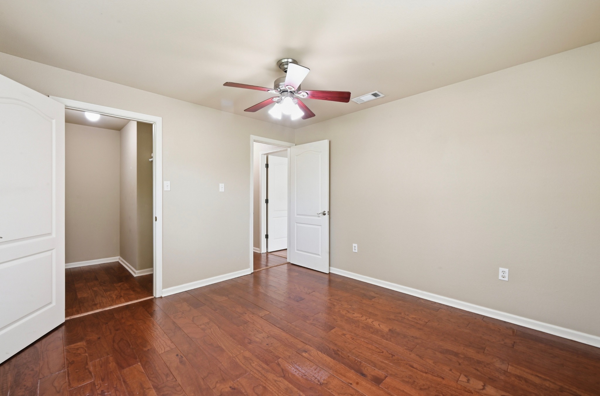 1127 Parr Street Luling, TX 78648 - Photo 11 of 20 Rich hardwood floors flow through this bedroom, complemented by a convenient ceiling fan for comfort.