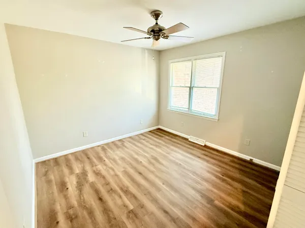 a view of a hallway with wooden floor and stairs