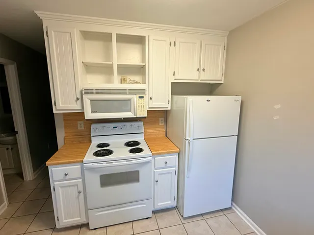 a white refrigerator freezer and a stove sitting inside of a kitchen