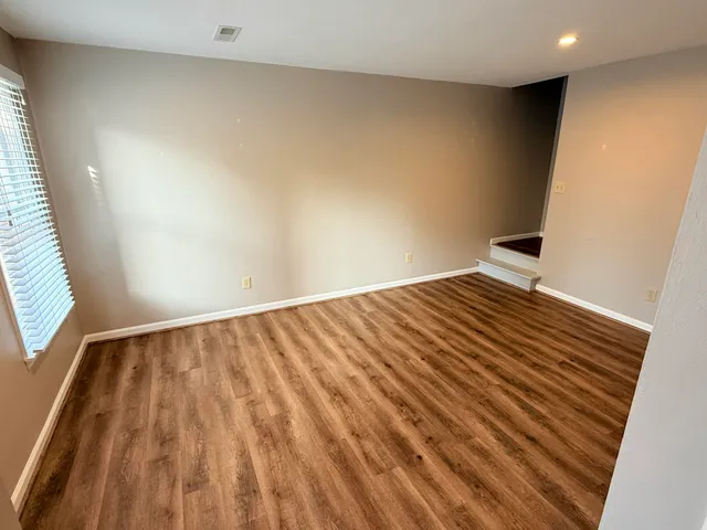 a view of empty room with wooden floor
