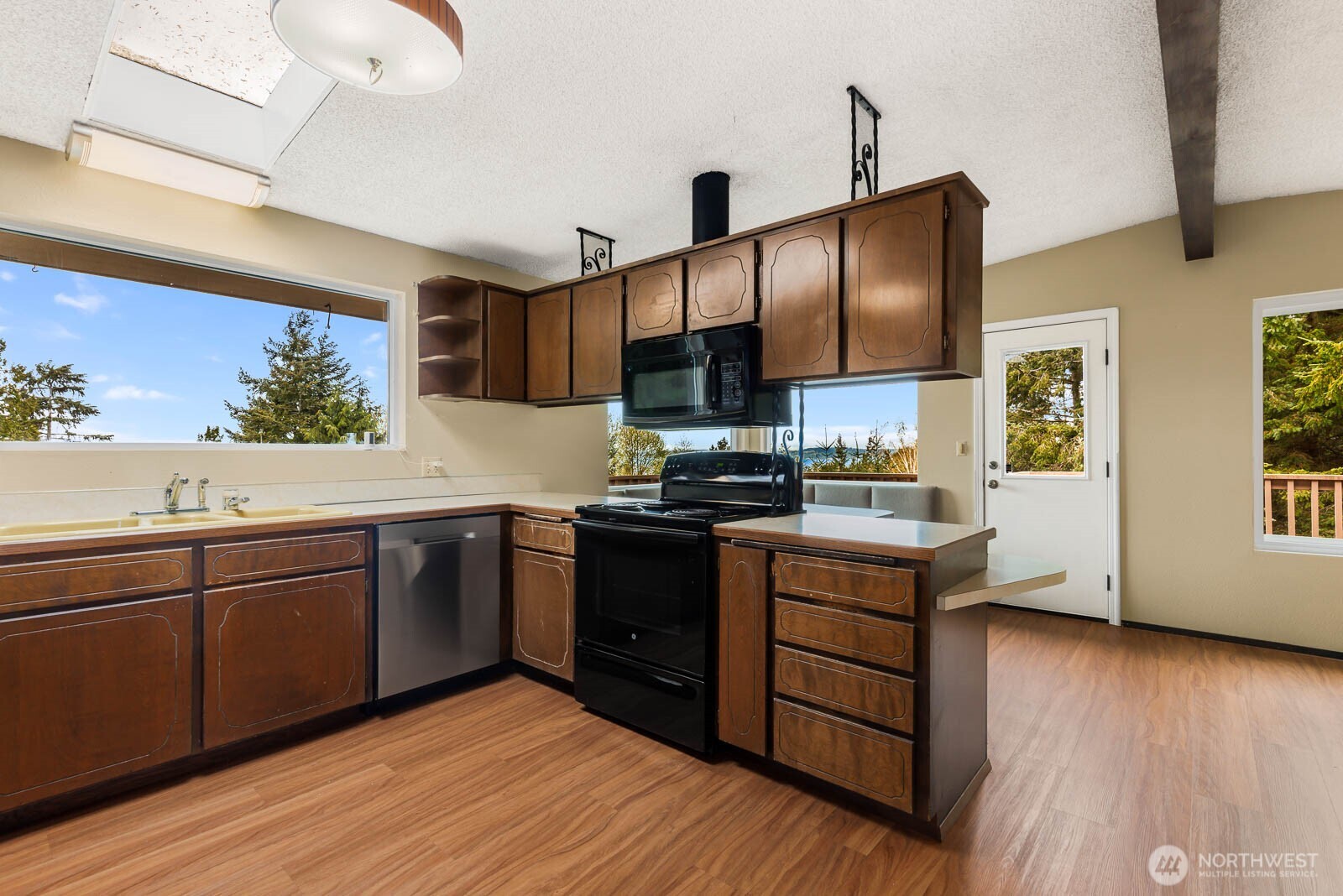 7413 Soundview Drive Edmonds, WA 98026 - Photo 15 of 31 a kitchen with stainless steel appliances granite countertop wooden cabinets a stove a sink and a large window