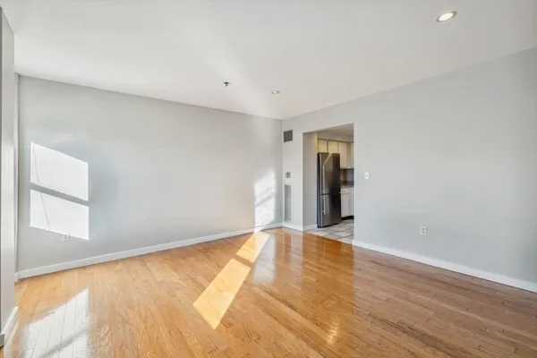 a view of an empty room with wooden floor