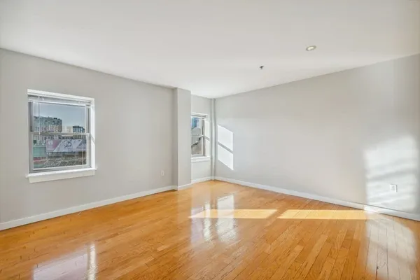 a view of empty room with wooden floor