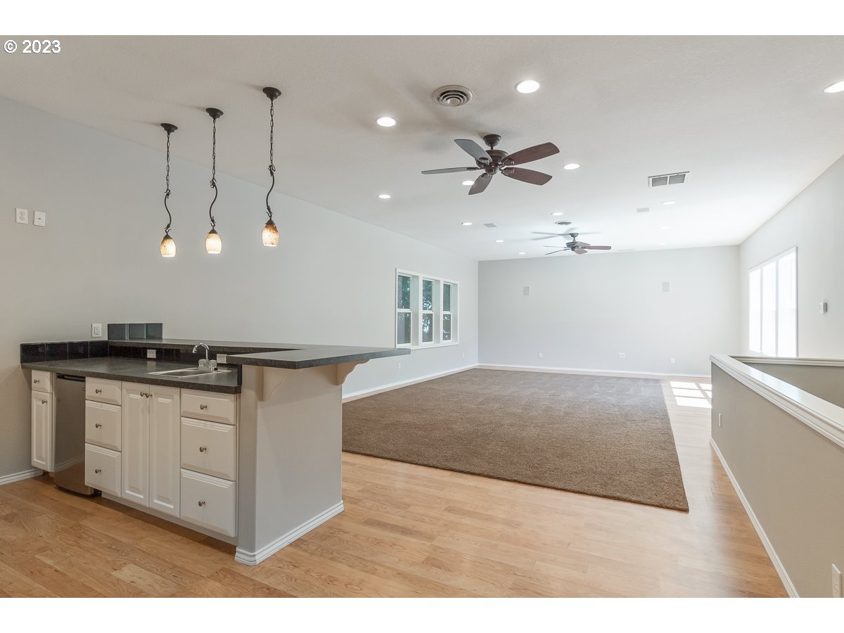 8580 Southwest Thoroughbred Place Beaverton, OR 97008 - Photo 15 of 43 a kitchen with stainless steel appliances granite countertop a sink a stove and a refrigerator