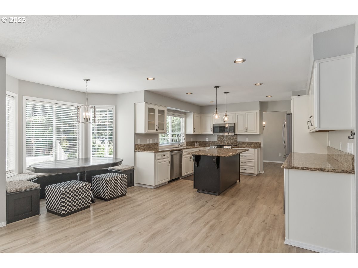 8580 Southwest Thoroughbred Place Beaverton, OR 97008 - Photo 7 of 43 a open kitchen with granite countertop a sink cabinets and stainless steel appliances