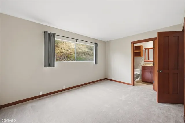 an empty room with closet and a bathroom