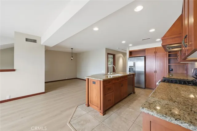 a large kitchen with stainless steel appliances granite countertop a large counter top and a stove