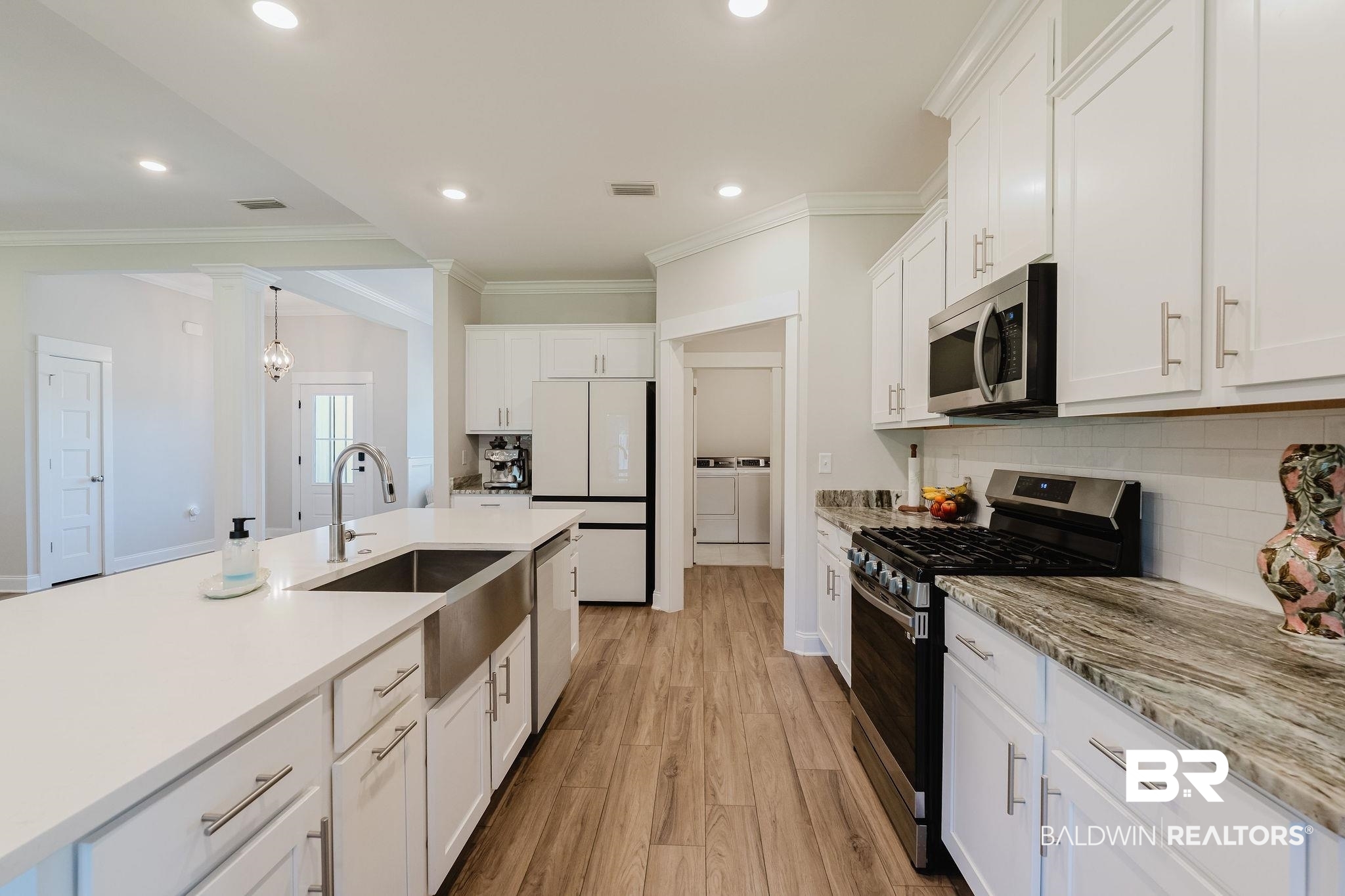 7872 Calverton Street Foley, AL 36535 - Photo 39 of 76 Contemporary kitchen featuring white cabinetry, wood-finish flooring, a stainless steel apron front sink, and recessed lighting