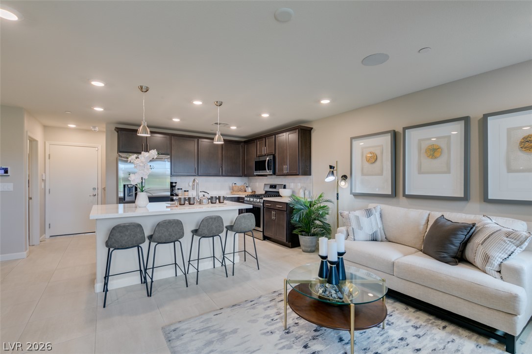 653 Pickled Pepper Place Henderson, NV 89011 - Photo 9 of 35 An open concept living area seamlessly blends a modern kitchen with a comfortable lounge space.