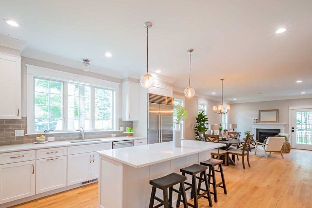 18 Pine Knoll Road Lexington, MA 02420 - Photo 18 of 42 a open kitchen with stainless steel appliances granite countertop a stove a sink a oven a dining table and chairs with wooden floor