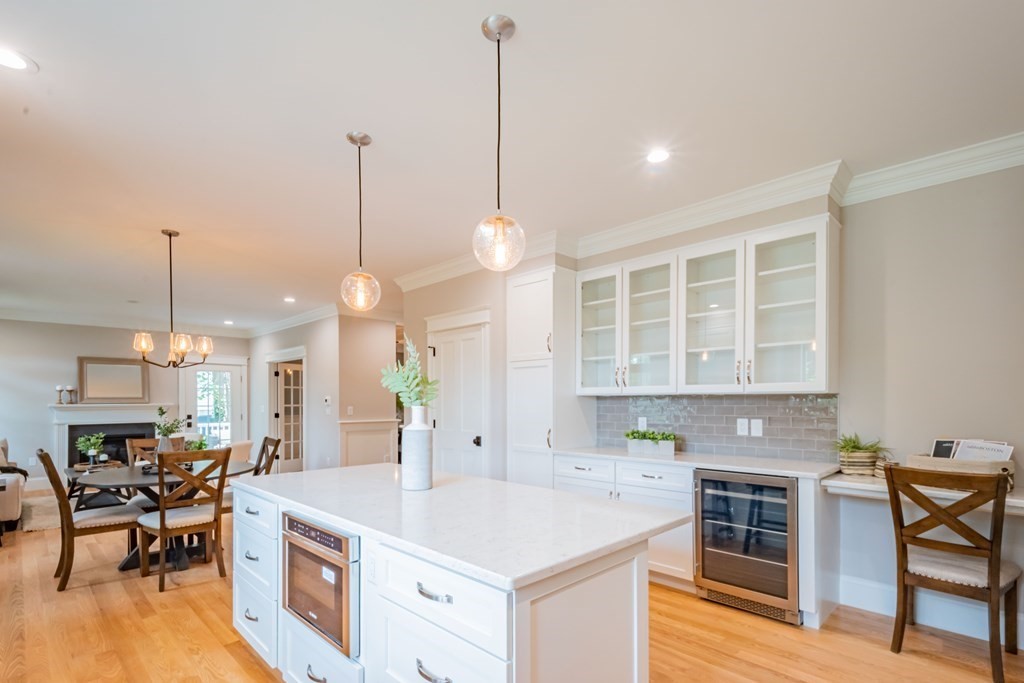 18 Pine Knoll Road Lexington, MA 02420 - Photo 19 of 42 a open kitchen with stainless steel appliances granite countertop a stove a kitchen island a dining table and chairs with wooden floor