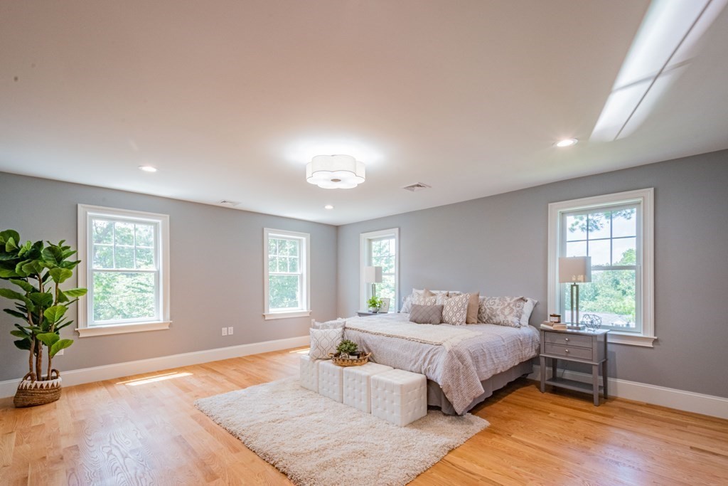 18 Pine Knoll Road Lexington, MA 02420 - Photo 23 of 42 a bedroom with a large bed windows and wooden floor