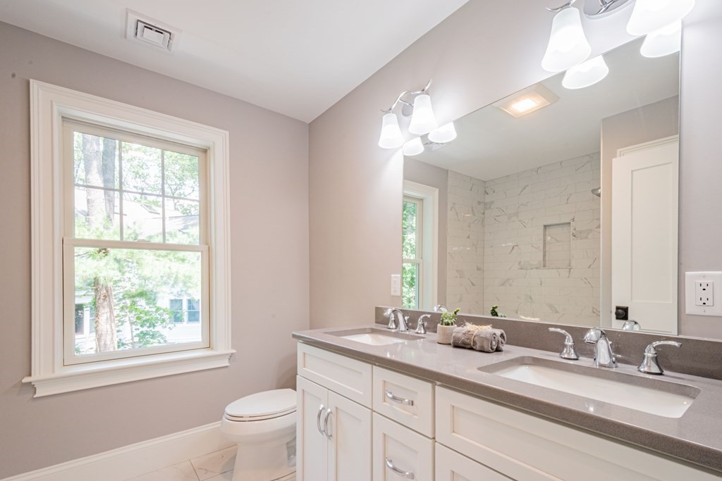 18 Pine Knoll Road Lexington, MA 02420 - Photo 33 of 42 a bathroom with a granite countertop double vanity sink a toilet and a window