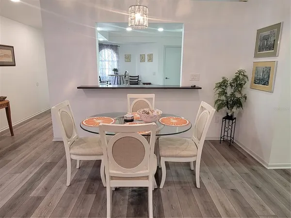 a dining room with furniture a chandelier and wooden floor